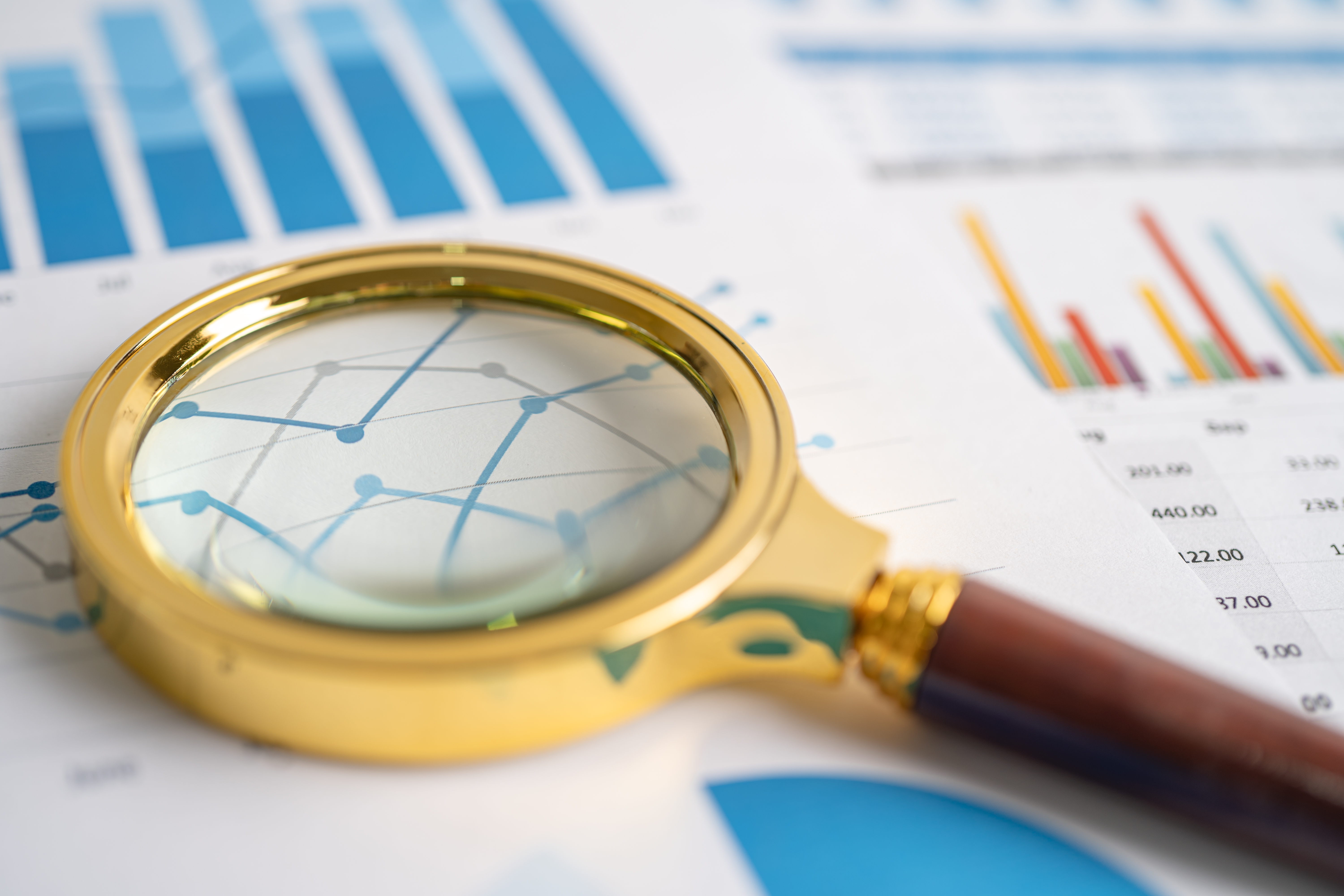 Lupa sobre gráficos e documentos durante uma auditoria